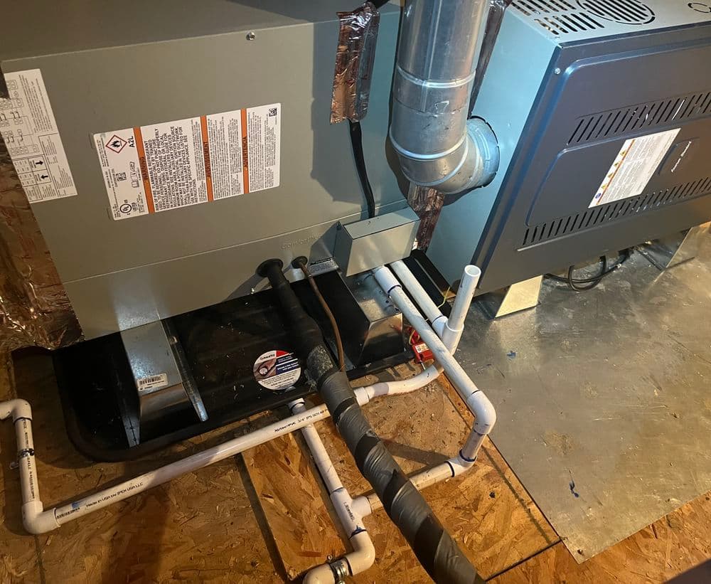 Furnace installation with gas pipes and ductwork in a basement setting.